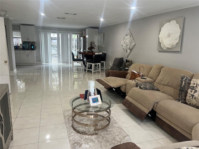 living room with light tile patterned floors and ornamental molding