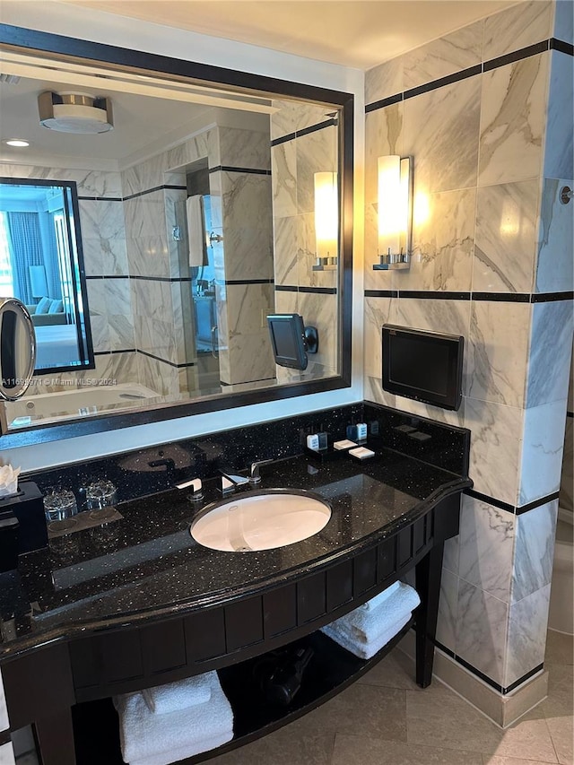 bathroom with tile patterned flooring, vanity, and tile walls