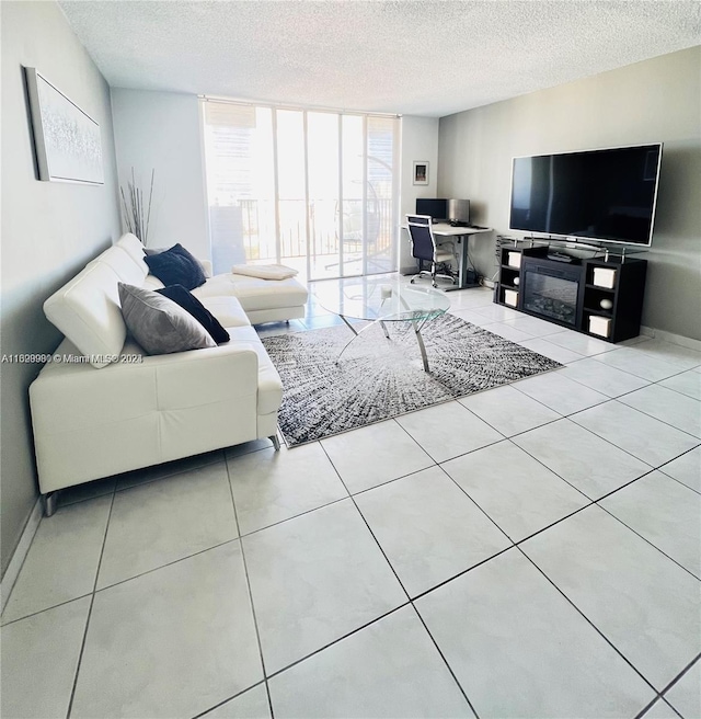 living room with light tile patterned flooring, a textured ceiling, and a wall of windows