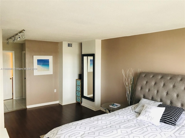 bedroom with a textured ceiling and dark wood-type flooring