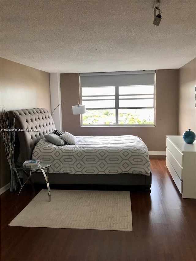 bedroom featuring dark hardwood / wood-style floors and a textured ceiling