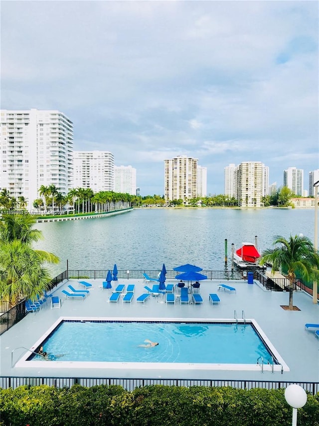 view of swimming pool with a patio area and a water view