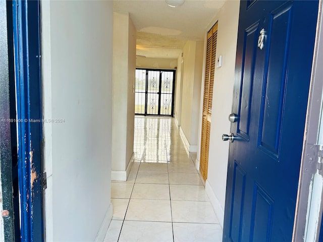 hall featuring light tile patterned floors