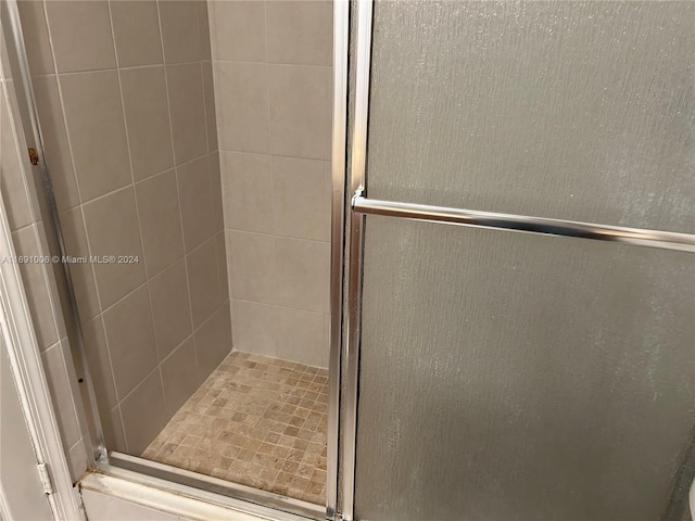 bathroom featuring a shower with door