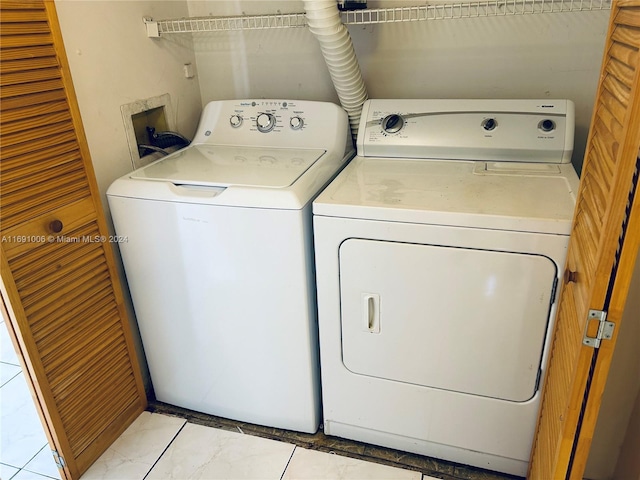 laundry area with light tile patterned flooring and washing machine and clothes dryer