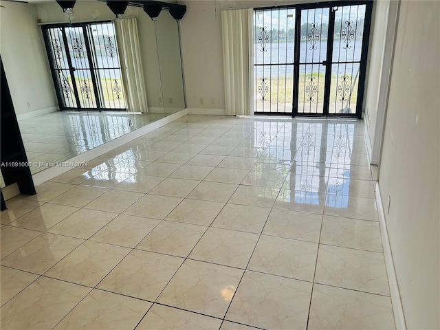 tiled empty room featuring a water view