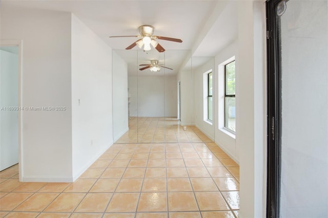 tiled empty room featuring ceiling fan