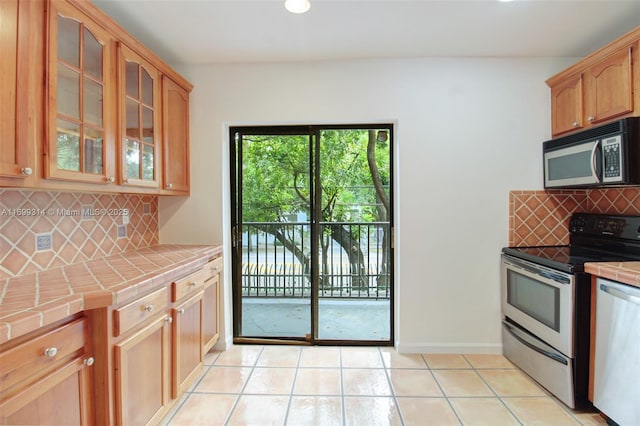 kitchen featuring tile counters, light tile patterned floors, and stainless steel appliances