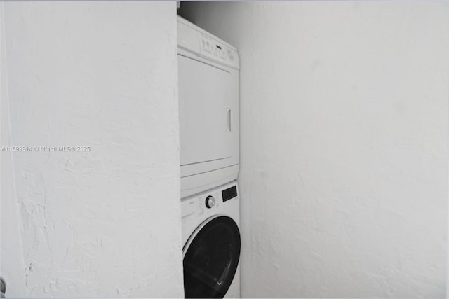 washroom featuring stacked washer / drying machine