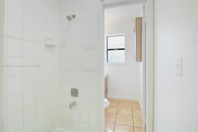 bathroom featuring tile patterned flooring, vanity, toilet, and tiled shower