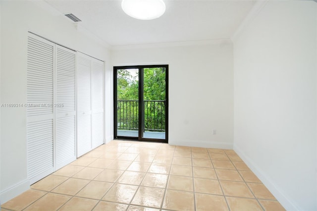 unfurnished bedroom with access to exterior, light tile patterned floors, a closet, and crown molding