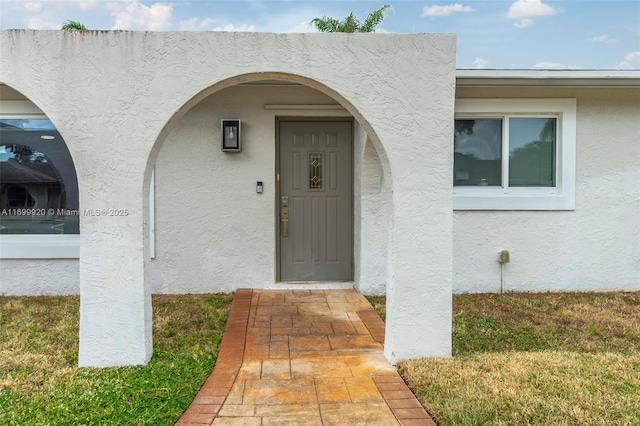 entrance to property with a lawn