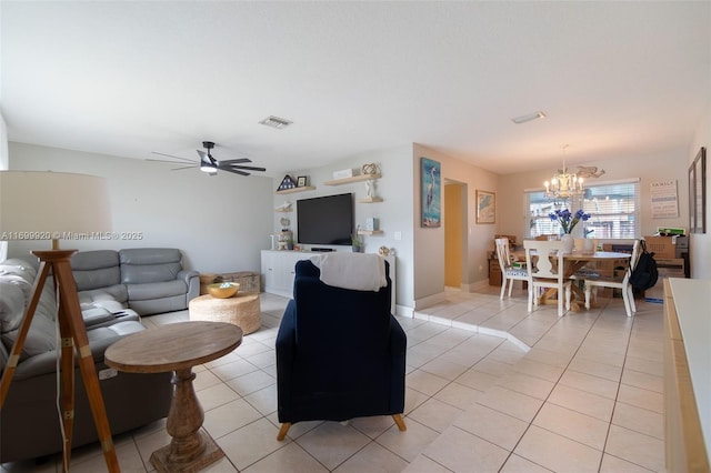 living room featuring ceiling fan with notable chandelier and light tile patterned floors