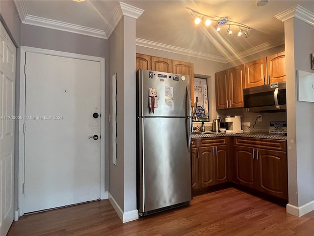 kitchen with light stone counters, crown molding, dark wood-type flooring, and appliances with stainless steel finishes