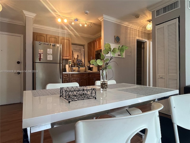 kitchen featuring dark hardwood / wood-style flooring, stainless steel fridge, crown molding, and a center island