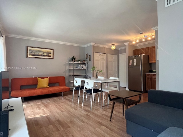 living room featuring crown molding and light hardwood / wood-style flooring