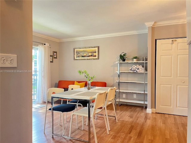 dining area with light hardwood / wood-style floors and ornamental molding