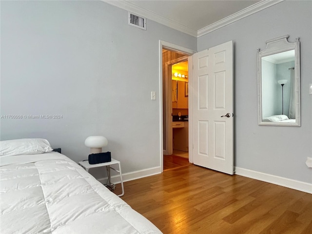 bedroom with hardwood / wood-style flooring and crown molding