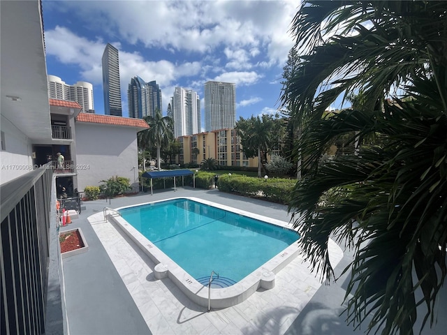 view of swimming pool featuring a trampoline and a patio