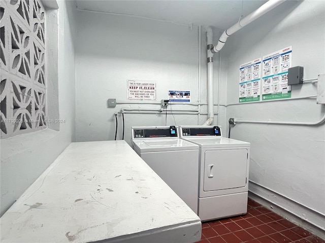 washroom with washer and dryer and dark tile patterned floors