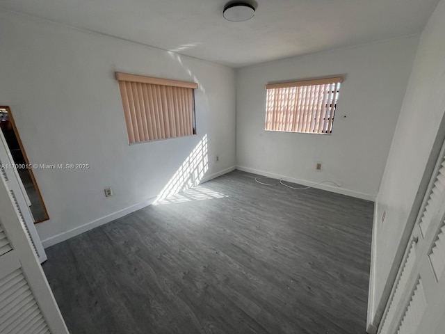 empty room with dark hardwood / wood-style flooring