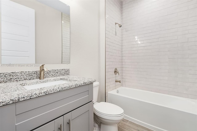 full bathroom featuring toilet, tiled shower / bath combo, vanity, and hardwood / wood-style flooring