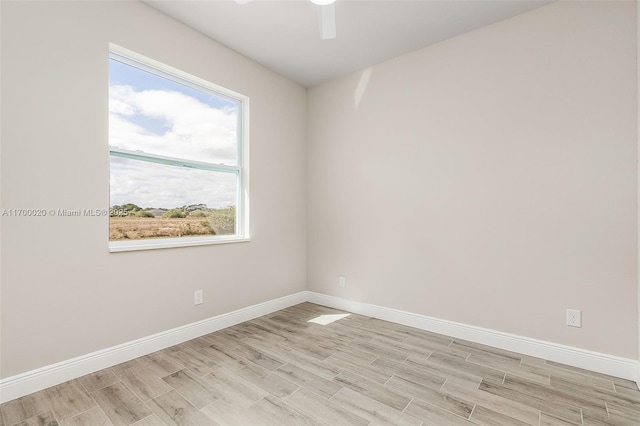 empty room with ceiling fan and light hardwood / wood-style flooring