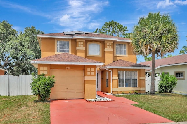 view of front of house with solar panels, a garage, and a front yard