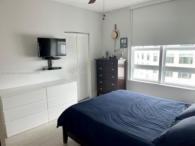 bedroom featuring ceiling fan, light hardwood / wood-style floors, and a closet