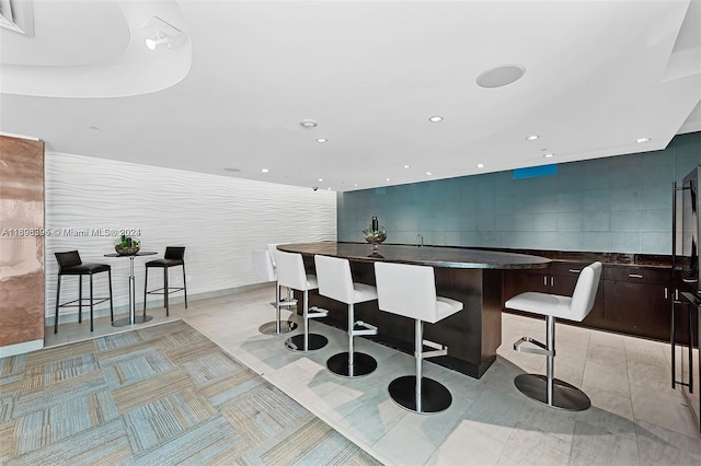 kitchen with a breakfast bar, a center island, and dark brown cabinetry