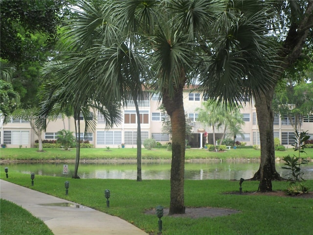 surrounding community featuring a lawn and a water view