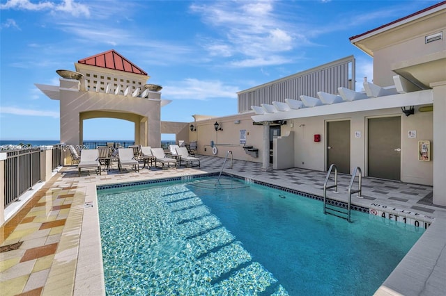 view of pool featuring a patio area, a pergola, and a water view