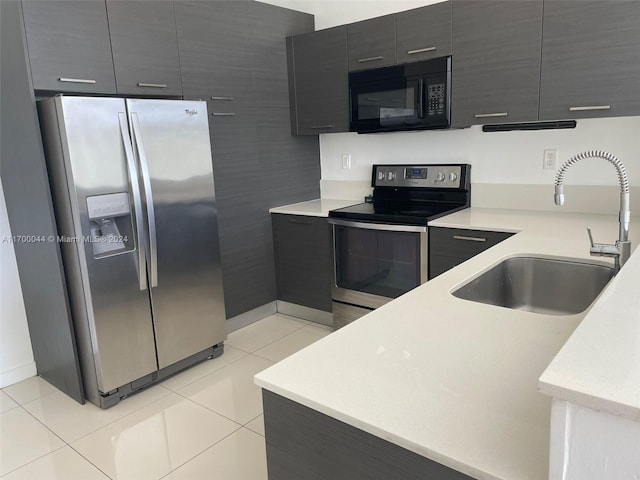 kitchen with light tile patterned flooring, sink, and appliances with stainless steel finishes