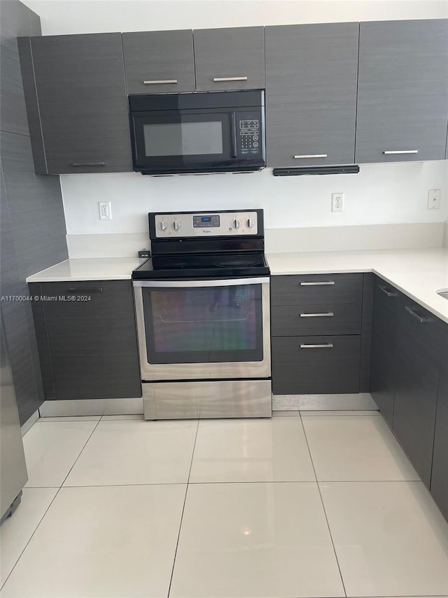 kitchen with electric range and light tile patterned flooring