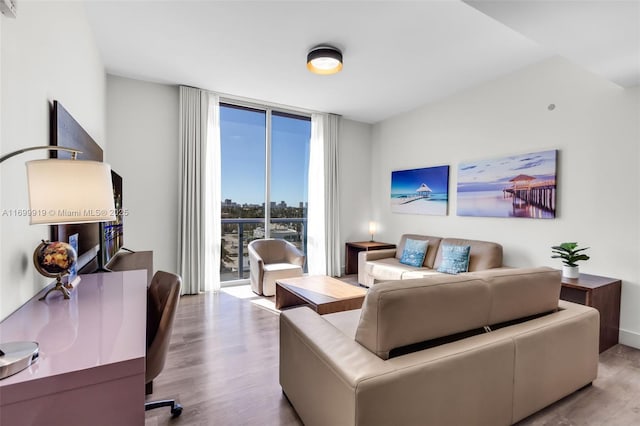 living room featuring light hardwood / wood-style flooring and a wall of windows