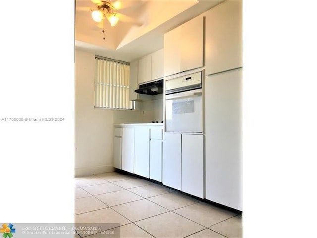 11960 NE 19th Dr Unit 24, North Miami, FL 33181 - kitchen featuring oven, light tile patterned floors, under cabinet range hood, a ceiling fan, and a raised ceiling