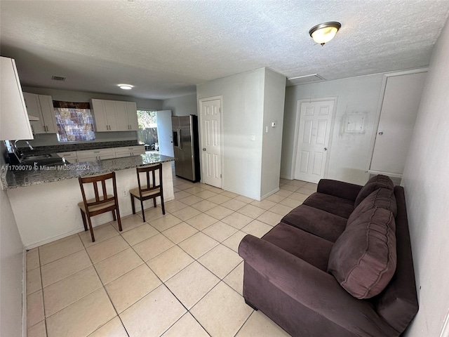 living room featuring light tile patterned floors and a textured ceiling