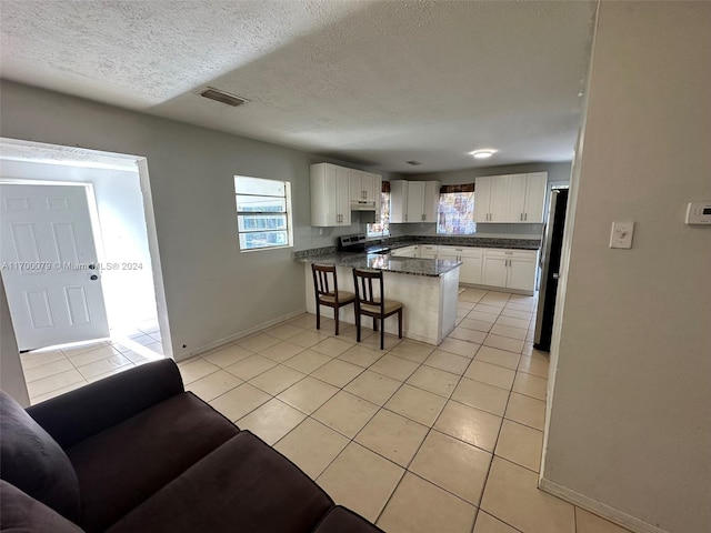 kitchen featuring white cabinetry, kitchen peninsula, stainless steel appliances, and light tile patterned floors