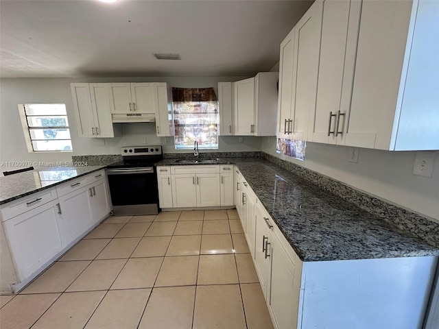 kitchen featuring electric stove, sink, white cabinets, and a healthy amount of sunlight