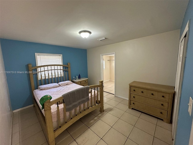 bedroom with ensuite bath and light tile patterned floors