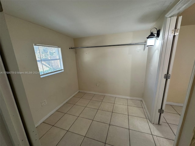 unfurnished bedroom featuring light tile patterned flooring and vaulted ceiling