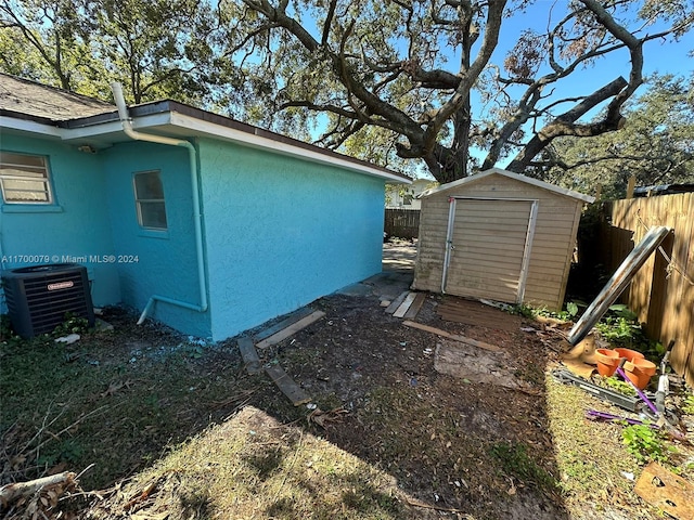 view of home's exterior featuring cooling unit and a storage unit