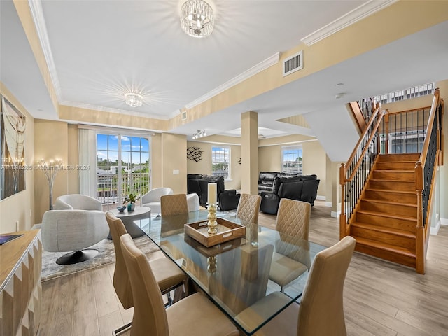 dining space featuring light hardwood / wood-style floors, plenty of natural light, and ornamental molding