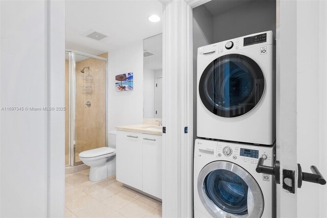 6799 Collins Ave Unit 1704, Miami Beach, FL 33141 - laundry area with stacked washer and clothes dryer and light tile patterned floors