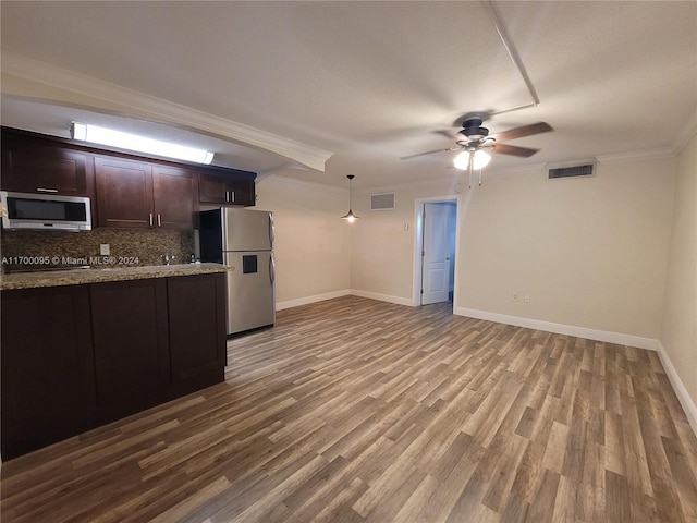 kitchen featuring dark brown cabinetry, backsplash, light hardwood / wood-style floors, appliances with stainless steel finishes, and ornamental molding