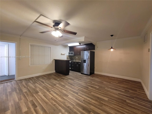 kitchen with dark wood-type flooring, decorative backsplash, ornamental molding, appliances with stainless steel finishes, and dark brown cabinets