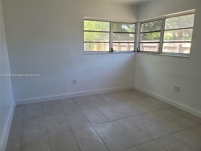 empty room featuring tile patterned flooring and a healthy amount of sunlight