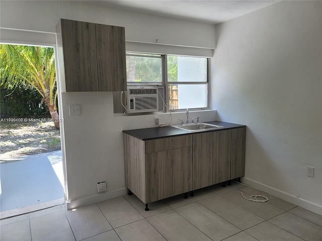 kitchen with light tile patterned flooring, a wealth of natural light, cooling unit, and sink