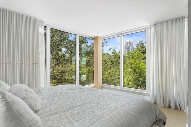 bedroom featuring a view of city and multiple windows