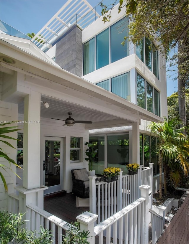 view of exterior entry featuring covered porch and a ceiling fan